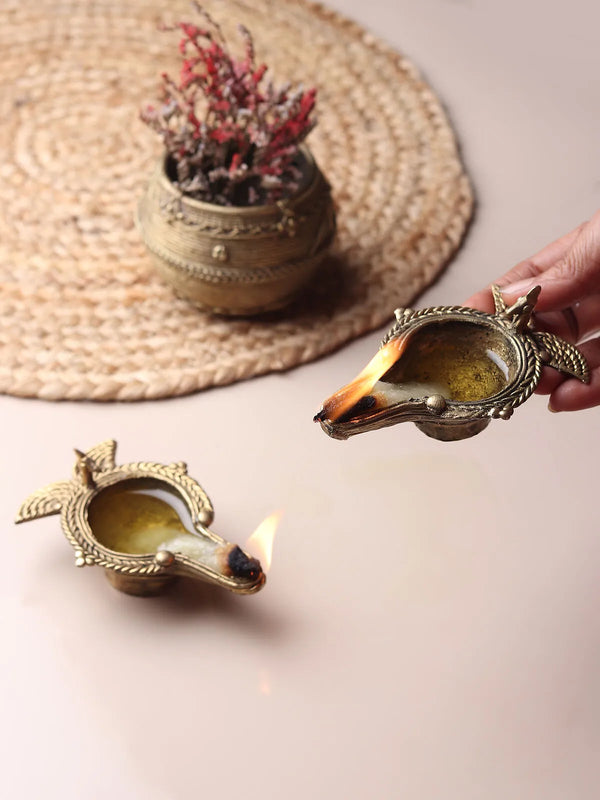 Handcrafted brass diya oil lamp with a shallow well and pinched wick lip, in warm golden brass