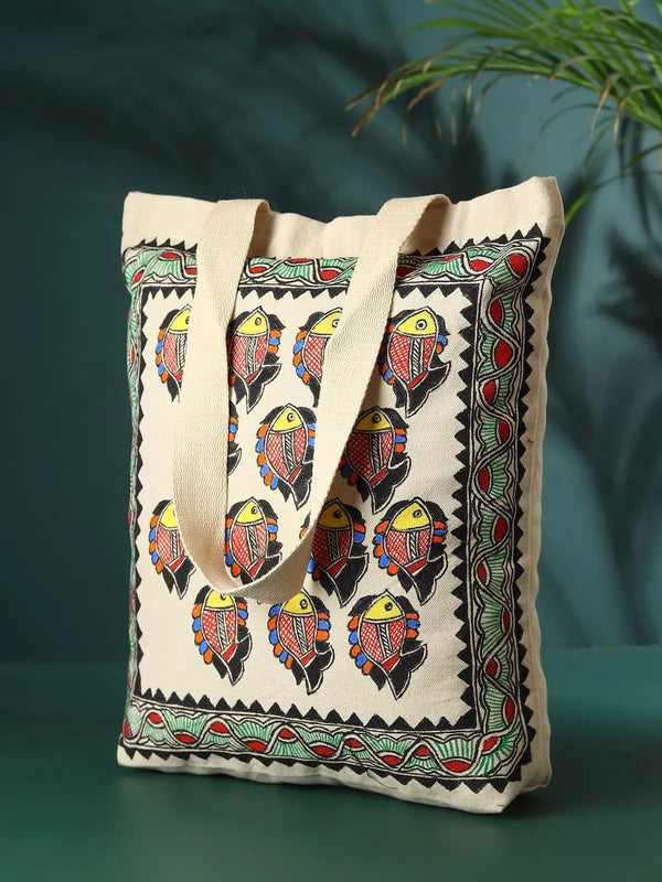 Hand-painted Madhubani fish jhola bag, showing the matsya motif outlined and filled by hand on the fabric
