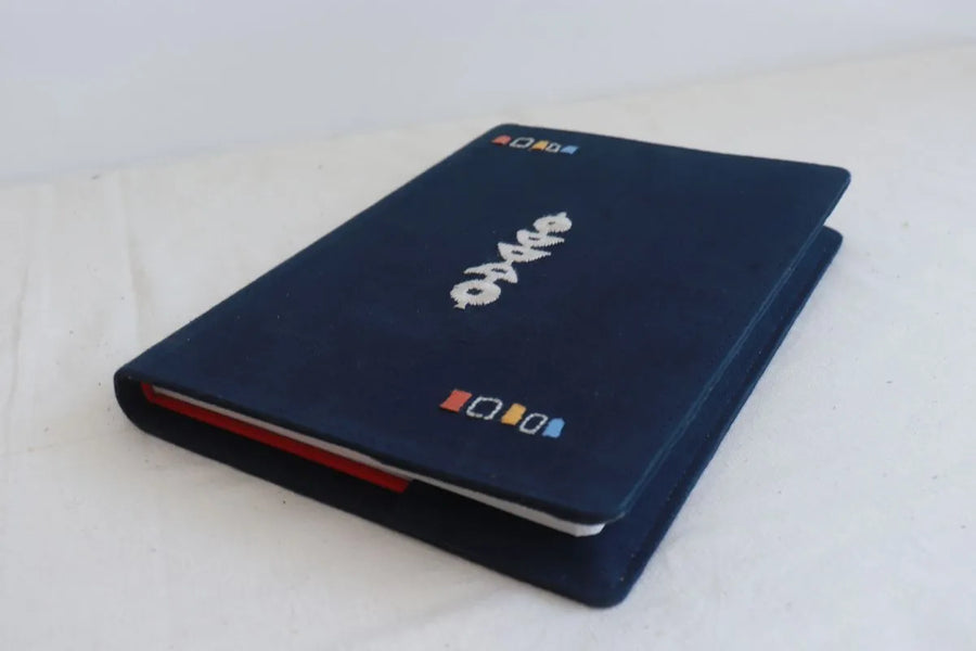 Navy embroidered diary open to show the handmade-paper inner pages