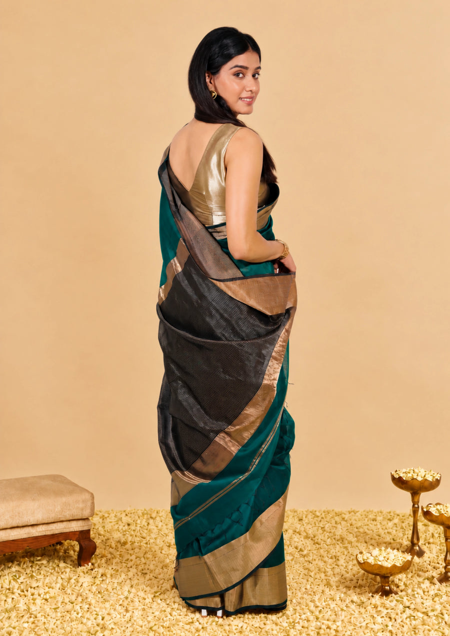 Back view of the bottle green Maheshwari saree showing the wide golden zari border and the pallu