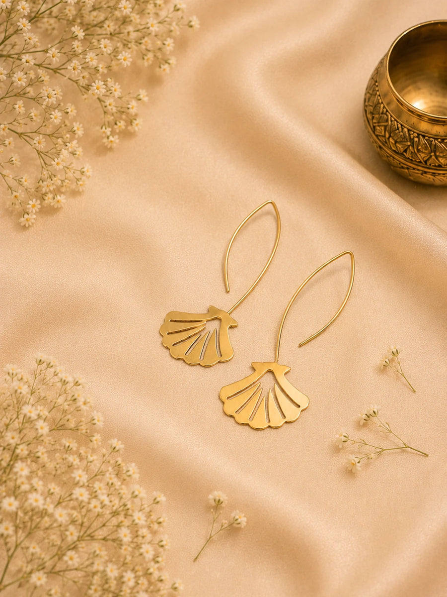 Pair of golden brass scallop shell earrings with slim cut-out ridges, each hanging from a long almond-shaped wire loop