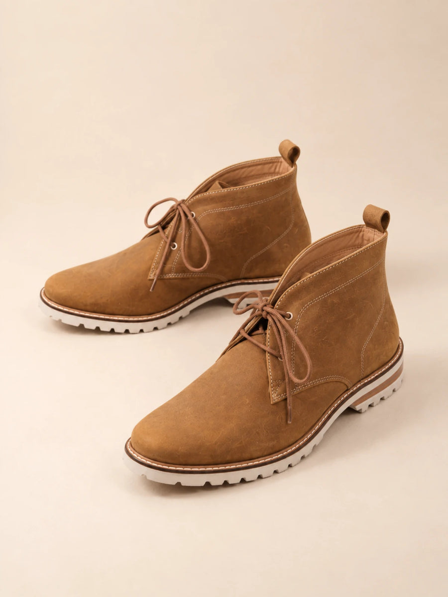 Tan suede ankle chukka boots with brown laces, contrast tan stitching and a stitched brown welt over a pale lug sole